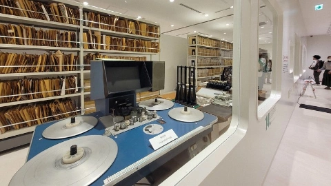 Комната со стеллажами бумаг, рядом стоит компьютер