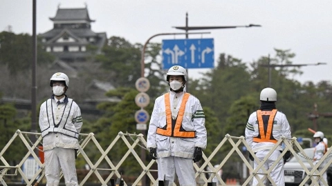 Трое мужчин в белой форме стоят на дороге