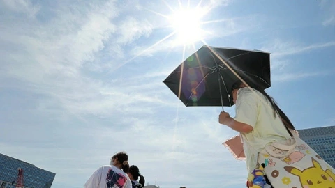 Женщина укрывается за чёрным плащом от палящего солнца