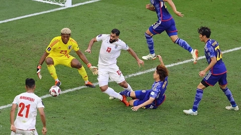 Футболист в синей форме бросается в ноги футболисту в белой форме, тот падает, рядом вратарь ловит мяч