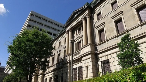 Трехэтажное здание, окружённое зелёными деревьями