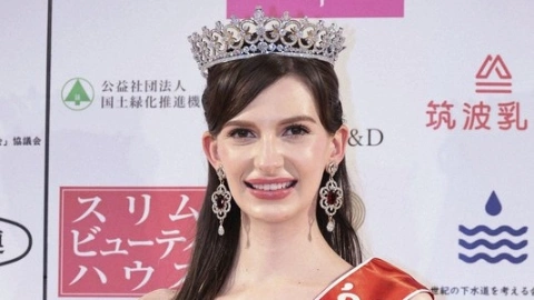 Девушка с чёрными волосами и чёрными глазами с короной на голове, широко улыбается