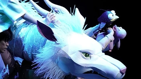 Группа актёров несёт огромную голову белого дракона по сцене